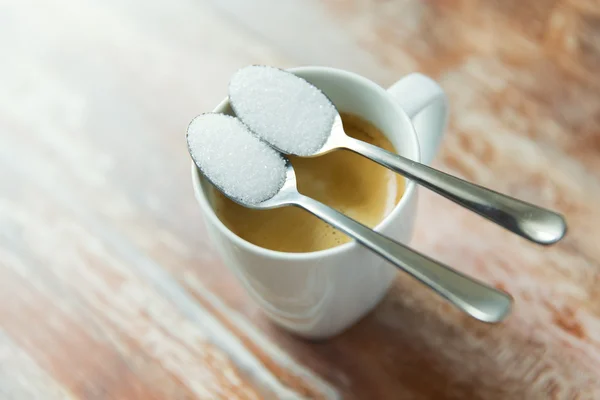 Close up of white sugar on teaspoon and coffee cup — Stock Photo, Image