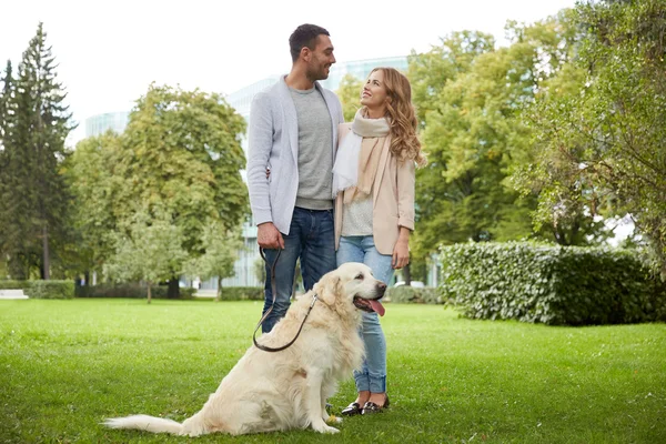 Feliz pareja con perro labrador paseando en la ciudad — Foto de Stock