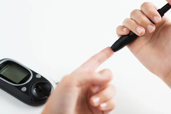 Close up of woman making blood test by glucometer — Stock Photo, Image