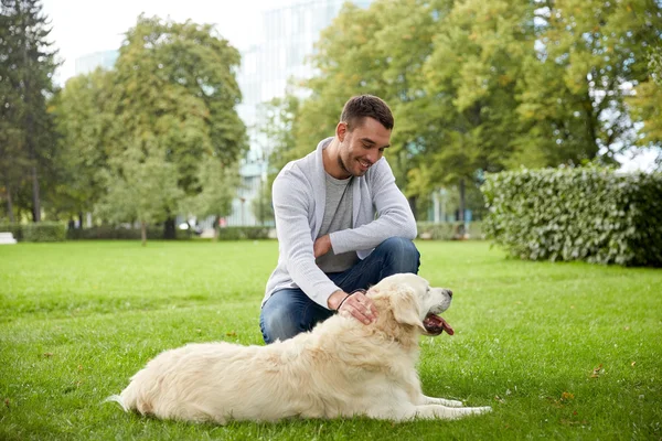 Счастливый человек с собакой-лабрадором, гуляющей по городу — стоковое фото