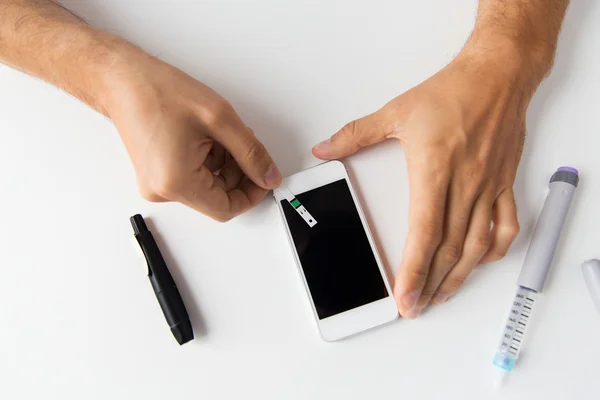 Primer plano del hombre con el teléfono inteligente haciendo análisis de sangre —  Fotos de Stock