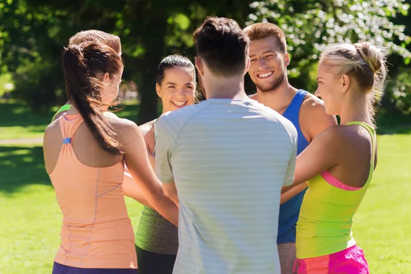 Grupo de amigos felices con manos en la parte superior al aire libre — Foto de Stock