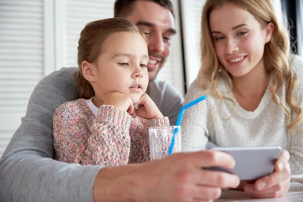 Glückliche Familie mit Smartphone im Restaurant — Stockfoto