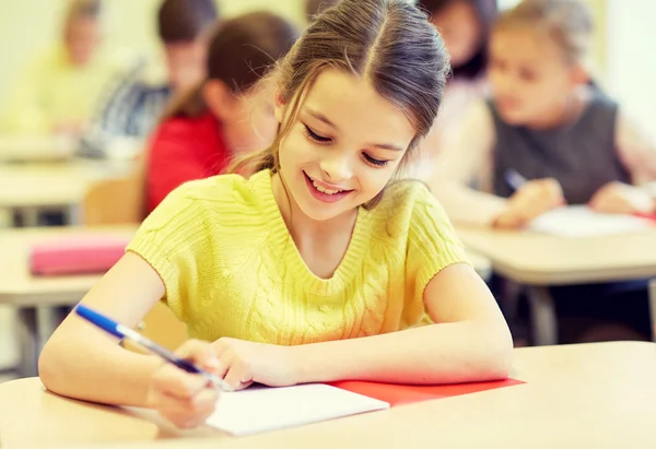 Group of school kids writing test in classroom Stock Image