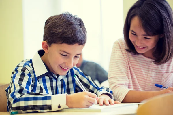 Group of school kids writing test in classroom Royalty Free Stock Photos