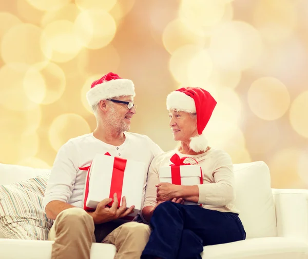 Щаслива старша пара в капелюхах Санти з подарунковими коробками — стокове фото