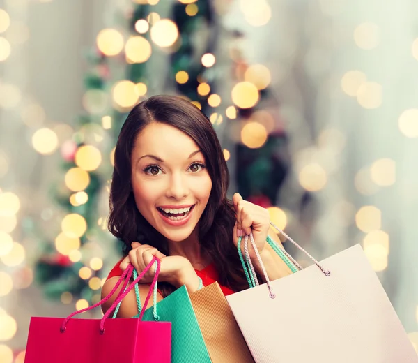 Mulher sorridente com sacos de compras coloridos — Fotografia de Stock