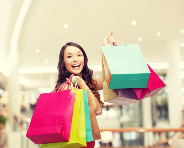 Lachende jonge vrouw met shopping tassen — Stockfoto