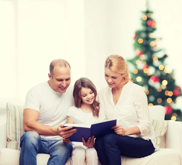 Famille heureuse avec livre à la maison — Photo