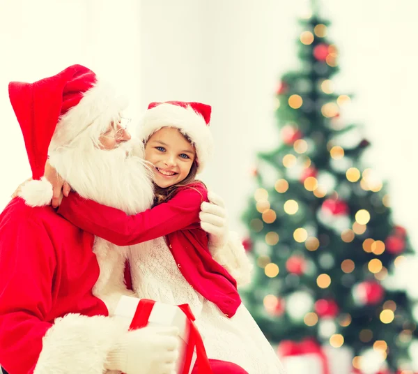 Lachende meisje met santa claus — Stockfoto