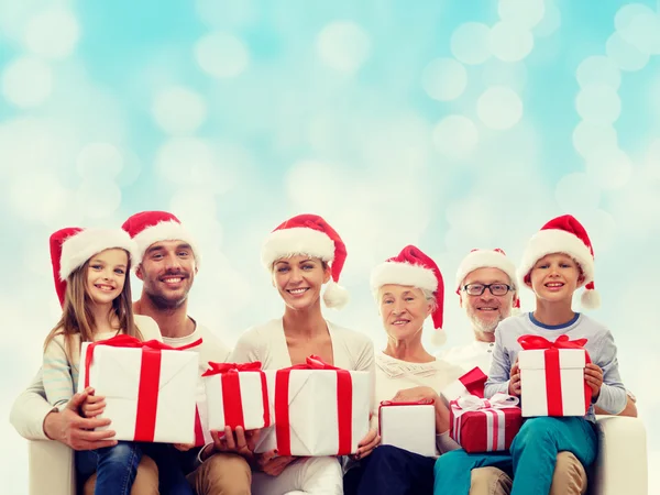 Happy family in santa helper hats with gift boxes — Stock Photo, Image