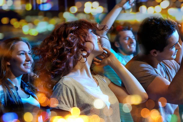 Amigos felizes dançando no clube noturno — Fotografia de Stock