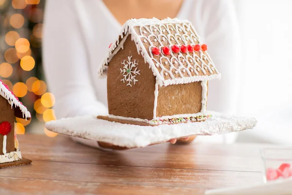 Close up of woman showing gingerbread house — Stock Photo, Image