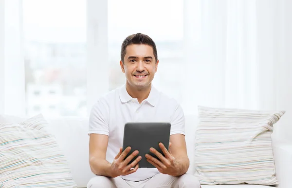 Lächelnder Mann, der zu Hause mit Tablet-PC arbeitet — Stockfoto