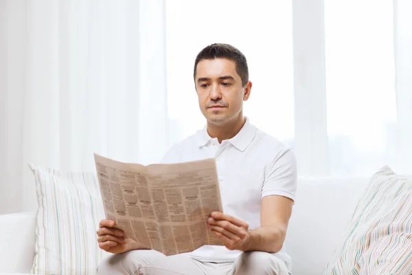 Een man die thuis kranten leest — Stockfoto