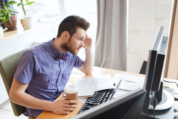 Creative male worker with computer drinking coffee — Stock Photo, Image