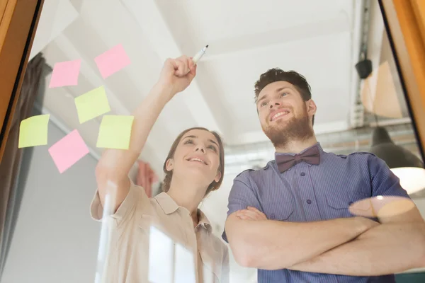 Feliz equipo creativo escribiendo en vidrio de oficina en blanco —  Fotos de Stock