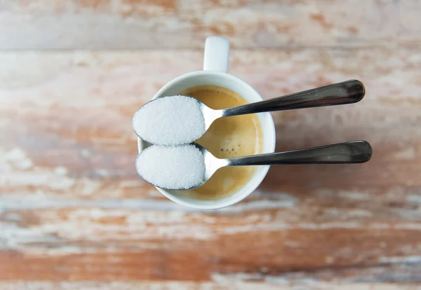 Крупним планом білий цукор на чайній ложці і чашці кави — стокове фото