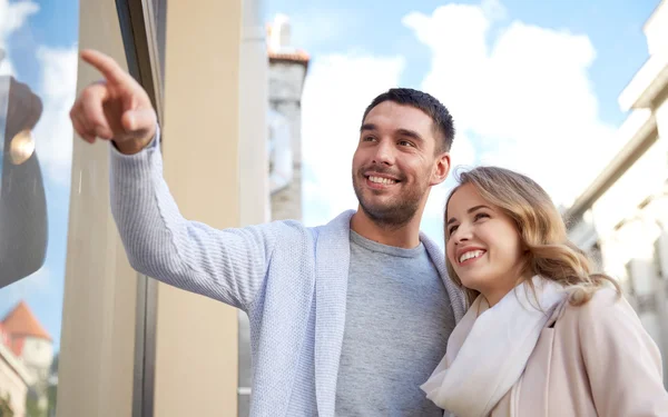 Feliz pareja de compras y mirando escaparate — Foto de Stock