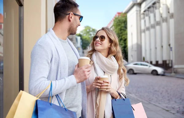 Lyckliga par med kassar och kaffe i city — Stockfoto