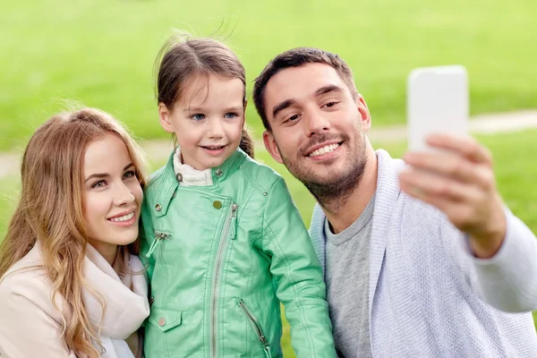 Szczęśliwa rodzina biorąc selfie przez smartphone na zewnątrz — Zdjęcie stockowe