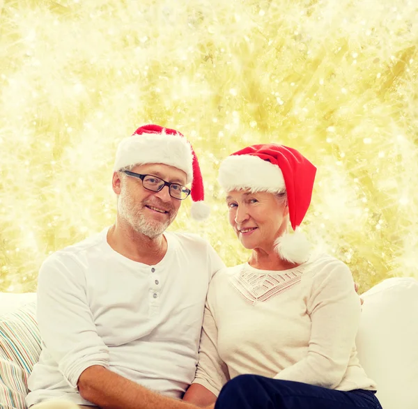 Šťastný starší pár v santa pomocníka klobouky — Stock fotografie