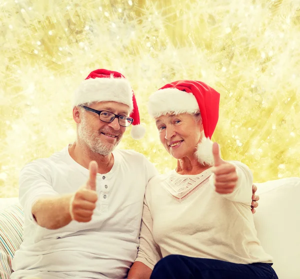 Счастливая старшая пара в шляпах помощников Санты — стоковое фото