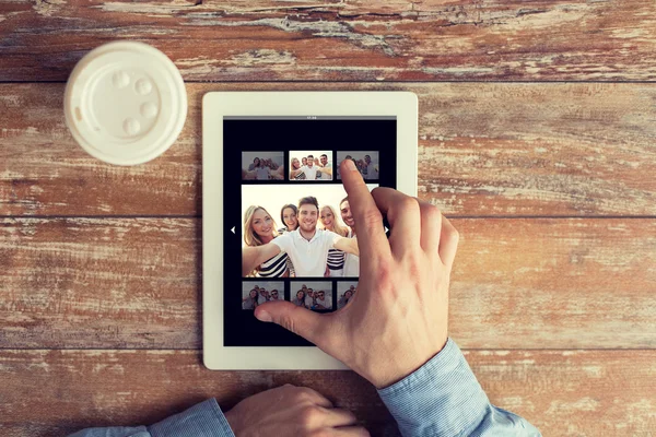 Primer plano de las manos masculinas con foto en la tableta pc — Foto de Stock