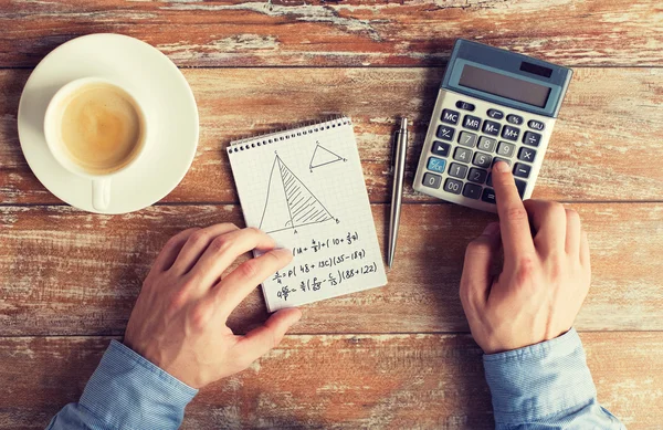 Perto de mãos com tarefa de resolução de calculadora — Fotografia de Stock