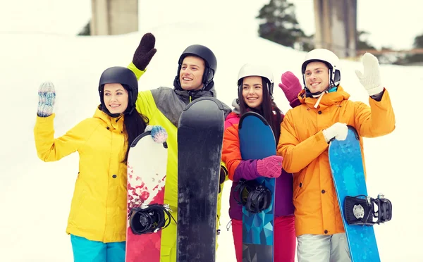 Glada vänner i hjälmar med snowboard — Stockfoto