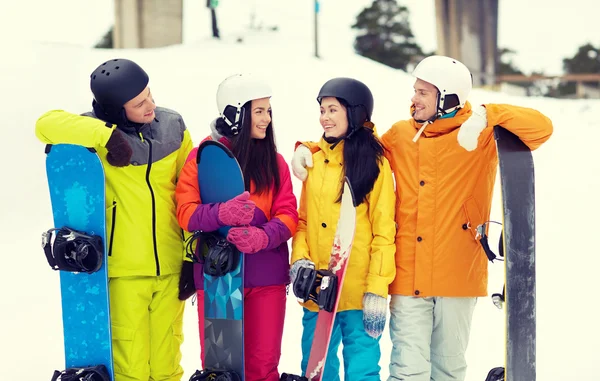 Glada vänner i hjälmar med snowboards talar — Stockfoto