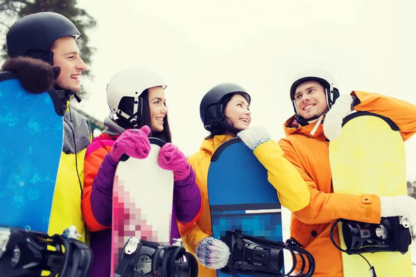 Happy friends in helmets with snowboards talking — Stock Photo, Image