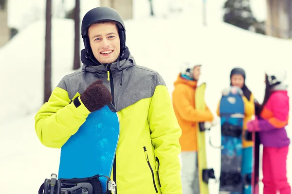 Happy friends in helmets with snowboards — Stock Photo, Image