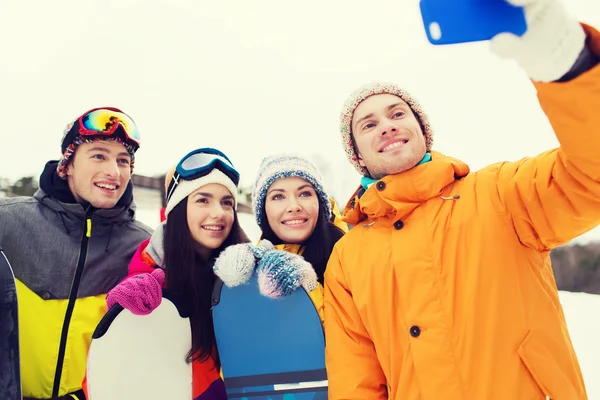 Happy friends with snowboards and smartphone — Stock Photo, Image