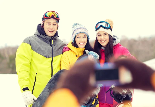 Gelukkige vrienden met snowboards en smartphone — Stockfoto