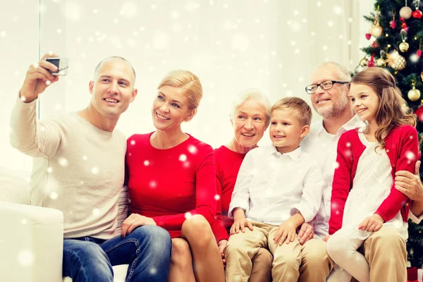 Família sorrindo com câmera em casa — Fotografia de Stock