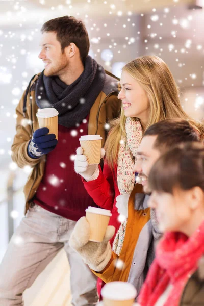 Glückliche Freunde mit Kaffeetassen auf der Eisbahn — Stockfoto