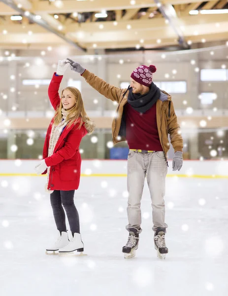 Feliz pareja cogida de la mano en pista de patinaje —  Fotos de Stock