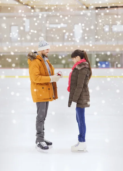 Feliz pareja con anillo de compromiso en pista de patinaje — Foto de Stock