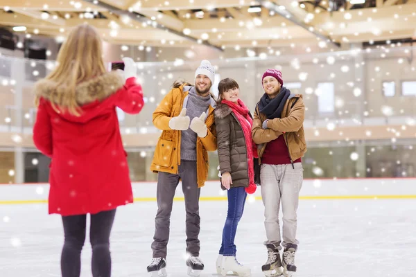 Amis heureux prenant des photos sur la patinoire — Photo