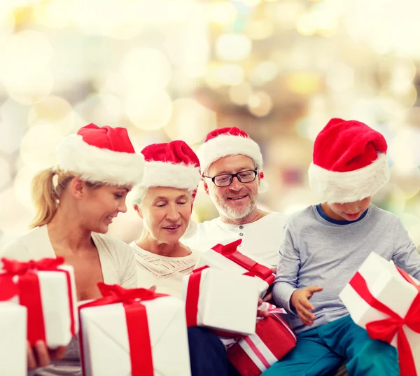 Famiglia felice in cappelli Babbo Natale aiutante con scatole regalo Fotografia Stock