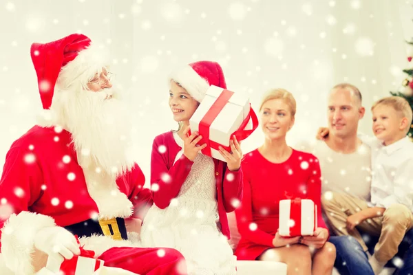 Famille souriante avec santa claus et cadeaux à la maison Images De Stock Libres De Droits