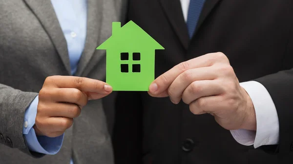 Empresário e empresária segurando casa verde — Fotografia de Stock