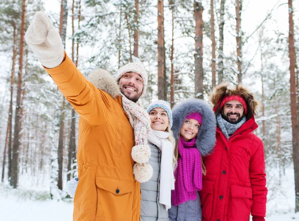 Grupo de hombres y mujeres sonrientes en el bosque de invierno — Foto de Stock