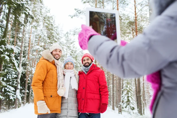 Amigos sonrientes con la tableta PC en el bosque de invierno —  Fotos de Stock