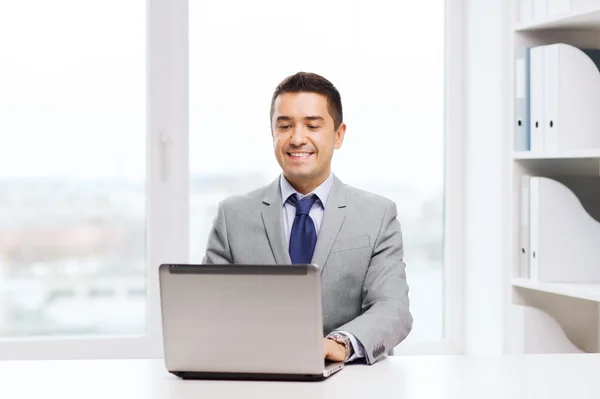 Hombre de negocios feliz trabajando con el ordenador portátil en la oficina — Foto de Stock