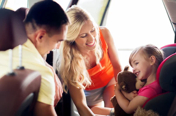 Щасливі батьки з маленькою дівчинкою на дитячому автокріслі — стокове фото