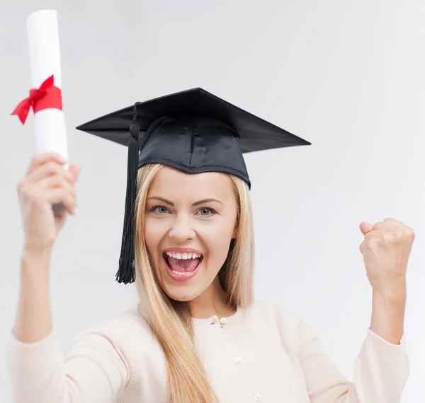 Estudiante en gorra de graduación con certificado — Foto de Stock