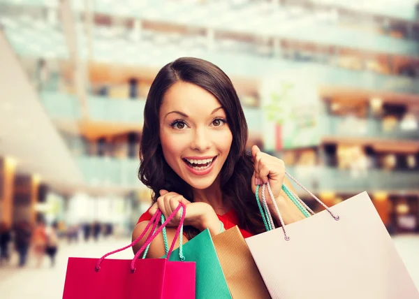 Mulher sorridente com sacos de compras coloridos — Fotografia de Stock