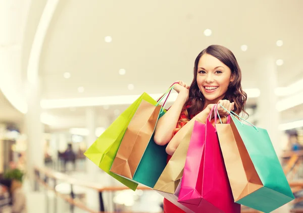 Sorrindo jovem mulher com sacos de compras — Fotografia de Stock